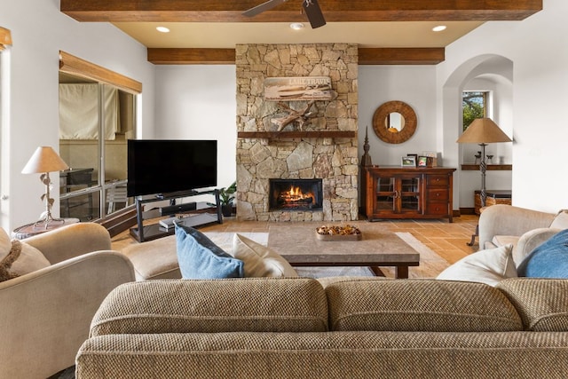 2804 Lohmans Ford Rd Unit B, Lago Vista, TX 78645 - living area with beamed ceiling, a fireplace, a ceiling fan, stone tile flooring, and arched walkways