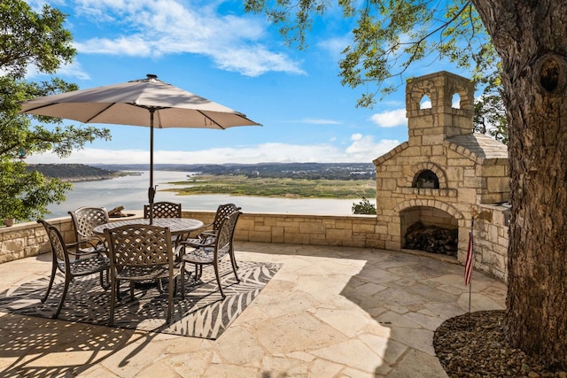 2804 Lohmans Ford Rd Unit B, Lago Vista, TX 78645 - view of patio featuring an outdoor stone fireplace, outdoor dining space, and a water view