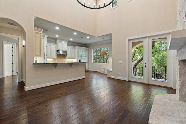 1036 Liberty Park Dr Unit 401/4A, Austin, TX 78746 - kitchen with a peninsula, ornamental molding, dark wood-style flooring, baseboards, and a kitchen breakfast bar