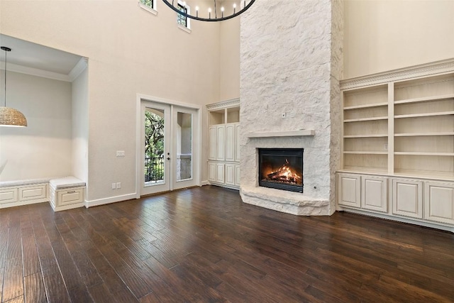 1036 Liberty Park Dr Unit 401/4A, Austin, TX 78746 - unfurnished living room featuring crown molding, dark wood-style floors, a fireplace, a chandelier, and built in features