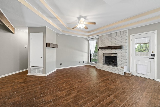 1008 Woodshadows Dr, Harker Heights, TX 76548 - unfurnished living room with ceiling fan, a tray ceiling, a fireplace, and wood finished floors