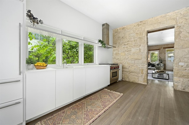 1112 W 10th St, Austin, TX 78703 - kitchen with stainless steel stove, wall chimney exhaust hood, white refrigerator, dark wood-style floors, and white cabinetry