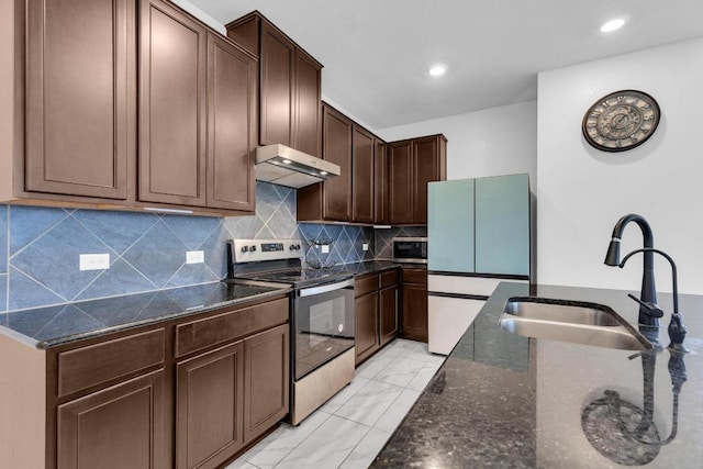 14516 Isidors Eagle Way, Elgin, TX 78621 - kitchen with appliances with stainless steel finishes, under cabinet range hood, a sink, dark stone countertops, and recessed lighting