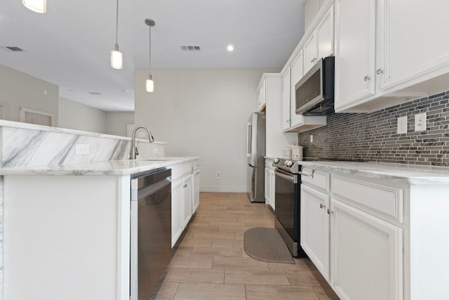 757 Canyon Bnd, Canyon Lake, TX 78133 - kitchen featuring appliances with stainless steel finishes, decorative backsplash, white cabinets, wood finish floors, and decorative light fixtures