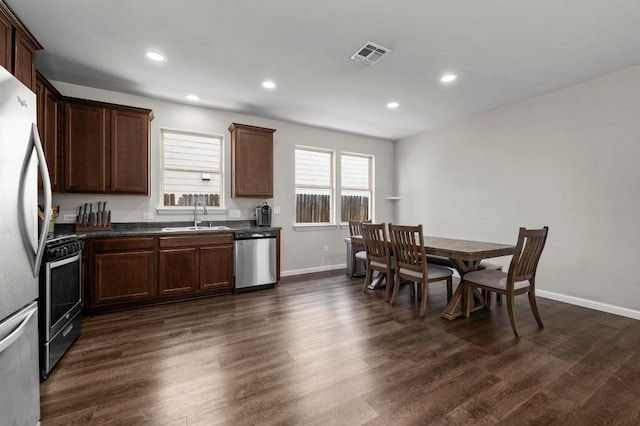 328 Triumph Rd, Buda, TX 78610 - kitchen featuring appliances with stainless steel finishes, dark countertops, dark wood-style flooring, recessed lighting, and dark brown cabinets