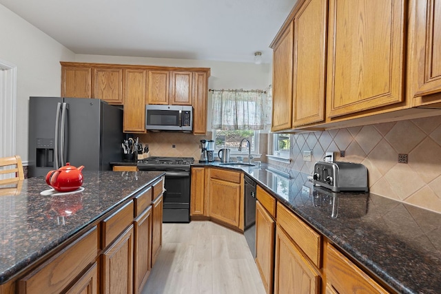 11713 Rydalwater Ln, Austin, TX 78754 - kitchen with black appliances, a sink, brown cabinetry, and light wood-type flooring