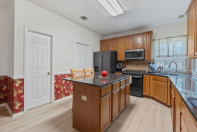 11713 Rydalwater Ln, Austin, TX 78754 - kitchen with stainless steel microwave, black gas stove, fridge with ice dispenser, light wood finished floors, and wallpapered walls