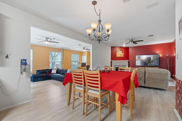 11713 Rydalwater Ln, Austin, TX 78754 - dining room featuring ceiling fan, light wood finished floors, a chandelier, and a fireplace