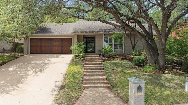 1302 Wilderness Dr, Austin, TX 78746 - mid-century home with an attached garage, brick siding, concrete driveway, a shingled roof, and a front yard