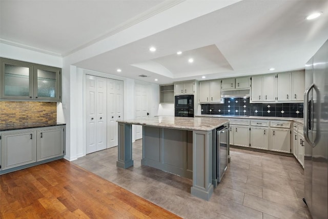 1302 Wilderness Dr, Austin, TX 78746 - kitchen with black appliances, backsplash, beverage cooler, light stone countertops, and a sink