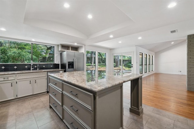 1302 Wilderness Dr, Austin, TX 78746 - kitchen featuring appliances with stainless steel finishes, vaulted ceiling, recessed lighting, healthy amount of natural light, and gray cabinets