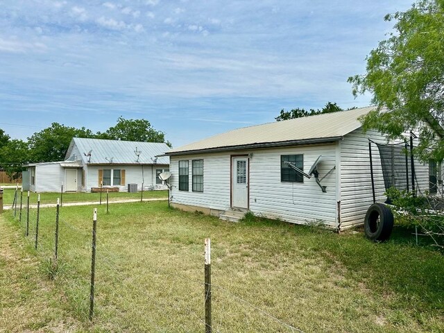 411 N Swenson St Unit 411, Falls City, TX 78113 - rear view of property with entry steps, metal roof, and central AC unit