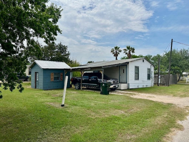 411 N Swenson St Unit 411, Falls City, TX 78113 - view of front of house featuring a carport, dirt driveway, and a front lawn