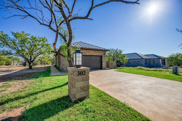 302 Parallel Cir, Horseshoe Bay, TX 78657 - view of front facade featuring a standing seam roof, concrete driveway, a front yard, metal roof, and stone siding