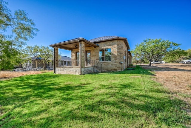 302 Parallel Cir, Horseshoe Bay, TX 78657 - back of house with a standing seam roof, a yard, metal roof, and stone siding