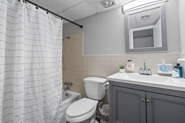 1800 Lavaca St Unit 307, Austin, TX 78701 - bathroom with vanity, shower / bathtub combination with curtain, a paneled ceiling, a wainscoted wall, and tile walls
