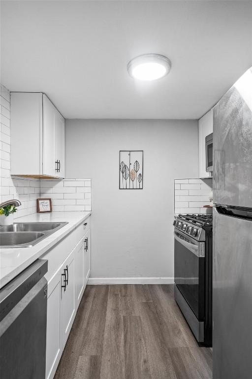 1800 Lavaca St Unit 307, Austin, TX 78701 - kitchen with stainless steel appliances, tasteful backsplash, dark wood finished floors, white cabinets, and light countertops