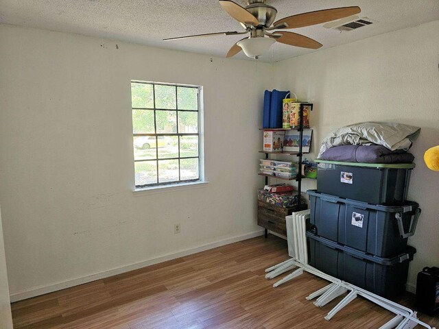 105 Park Dr S, Kyle, TX 78640 - empty room featuring wood finished floors, ceiling fan, baseboards, and a textured ceiling