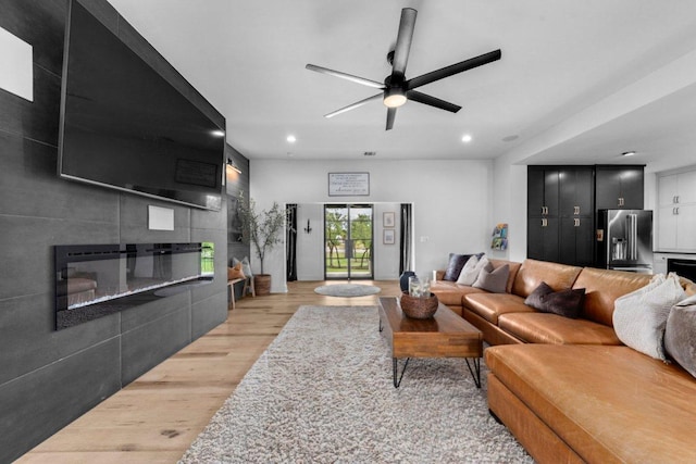 150 Wandering Oak Cir, Burnet, TX 78611 - living area featuring light wood finished floors, a tiled fireplace, ceiling fan, and recessed lighting
