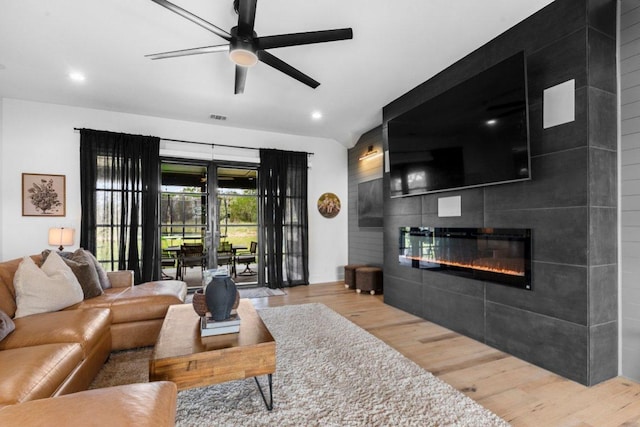 150 Wandering Oak Cir, Burnet, TX 78611 - living area with wood finished floors, a tiled fireplace, a ceiling fan, and recessed lighting