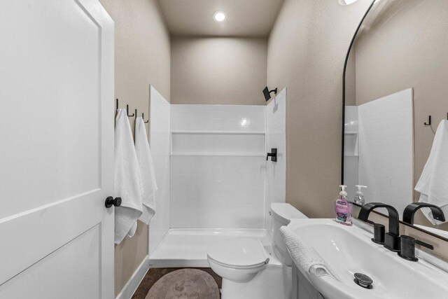 150 Wandering Oak Cir, Burnet, TX 78611 - full bathroom with a sink, tiled shower, and toilet
