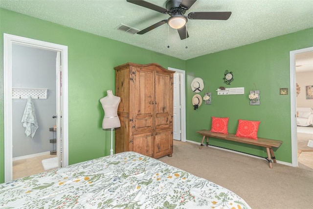 926 Zwicke St, Seguin, TX 78155 - carpeted bedroom with a textured ceiling, ceiling fan, and ensuite bath