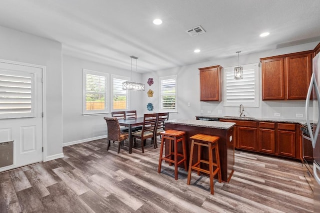529 Cinnamon Teal Ln, Leander, TX 78641 - kitchen with a sink, a center island, dark wood finished floors, recessed lighting, and pendant lighting