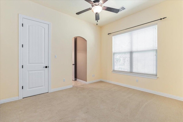 118 NE Verrena Way, Georgetown, TX 78628 - unfurnished bedroom featuring light colored carpet, arched walkways, baseboards, and ceiling fan