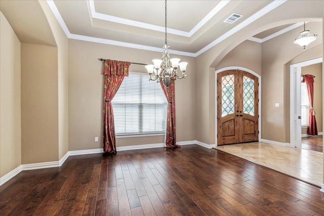 118 NE Verrena Way, Georgetown, TX 78628 - entrance foyer featuring arched walkways, a chandelier, hardwood / wood-style flooring, a tray ceiling, and baseboards