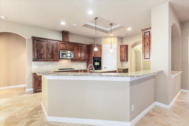 118 NE Verrena Way, Georgetown, TX 78628 - kitchen with stainless steel appliances, tasteful backsplash, arched walkways, light stone countertops, and recessed lighting
