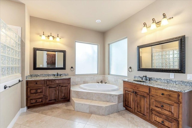 118 NE Verrena Way, Georgetown, TX 78628 - bathroom with a bath, two vanities, and tile patterned floors