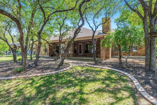 118 NE Verrena Way, Georgetown, TX 78628 - back of house featuring ceiling fan, a chimney, a lawn, and a patio area