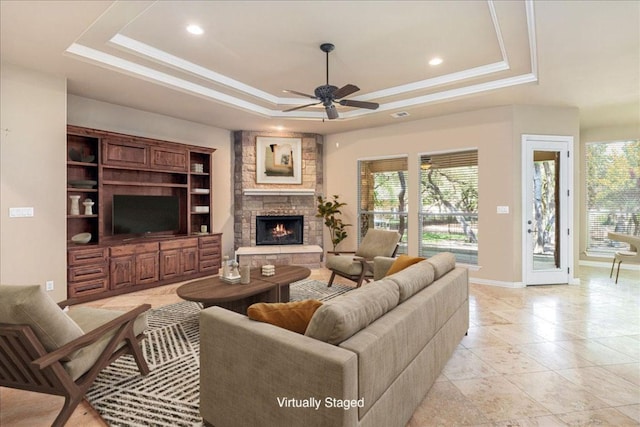 118 NE Verrena Way, Georgetown, TX 78628 - living area with a raised ceiling, a ceiling fan, a stone fireplace, baseboards, and recessed lighting