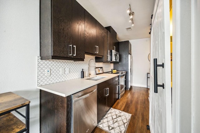 3114 S Congress Ave Unit 304, Austin, TX 78704 - kitchen featuring appliances with stainless steel finishes, a sink, light countertops, decorative backsplash, and dark wood-style floors