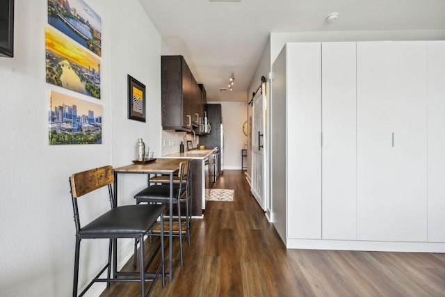 3114 S Congress Ave Unit 304, Austin, TX 78704 - corridor with a barn door, dark wood-style flooring, and baseboards