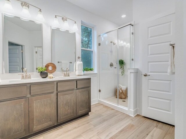 1108 Floradale Dr, Austin, TX 78753 - bathroom with double vanity, a shower stall, and wood finished floors
