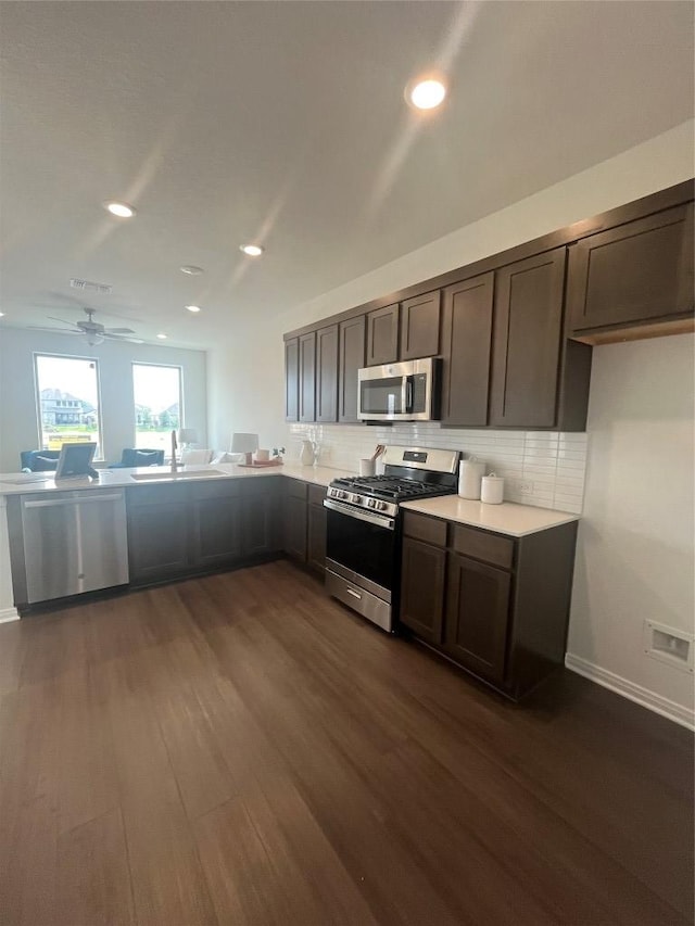 316 Witchhazel Way, San Marcos, TX 78666 - kitchen featuring appliances with stainless steel finishes, a sink, dark wood-type flooring, backsplash, and recessed lighting