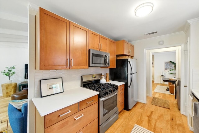 5202 Hedgewood Dr, Austin, TX 78745 - kitchen with stainless steel appliances, crown molding, light wood-style flooring, light countertops, and tasteful backsplash