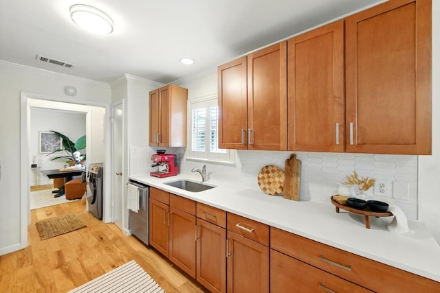 5202 Hedgewood Dr, Austin, TX 78745 - kitchen featuring a sink, light wood-style flooring, light countertops, stainless steel dishwasher, and ornamental molding