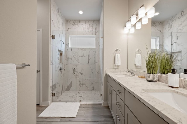 4356 Mayfield Ranch Blvd, Round Rock, TX 78681 - bathroom featuring a marble finish shower, double vanity, wood finished floors, and recessed lighting