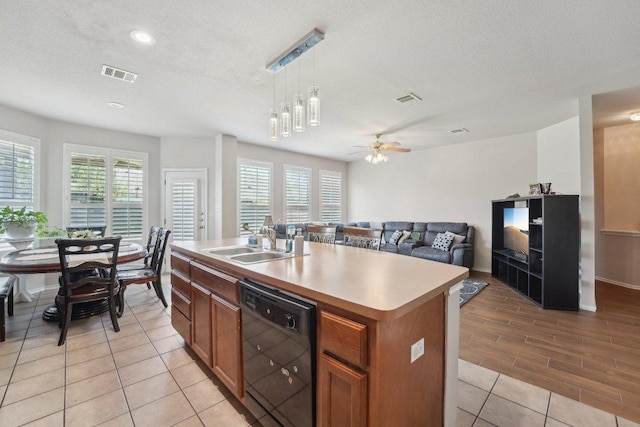 4013 Veiled Falls Dr, Pflugerville, TX 78660 - kitchen featuring dishwasher, a sink, brown cabinetry, plenty of natural light, and recessed lighting