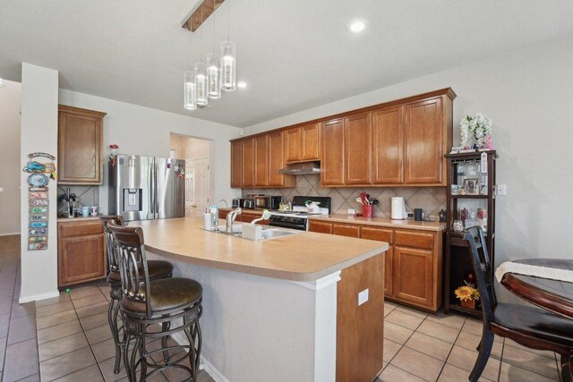 4013 Veiled Falls Dr, Pflugerville, TX 78660 - kitchen featuring stainless steel fridge, black range, under cabinet range hood, light tile patterned flooring, and recessed lighting