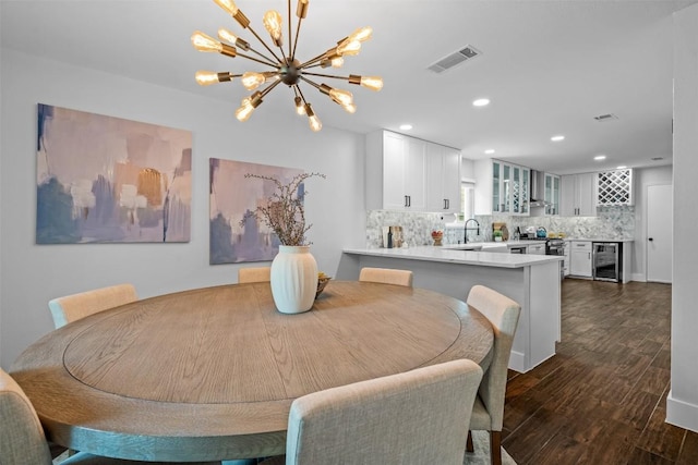 12420 Cassady Dr, Austin, TX 78727 - dining area featuring wine cooler, dark wood-style flooring, a chandelier, and recessed lighting