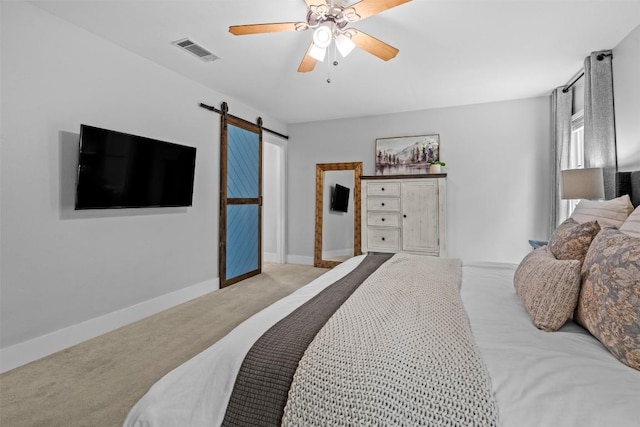 12420 Cassady Dr, Austin, TX 78727 - carpeted bedroom with a barn door, baseboards, and a ceiling fan