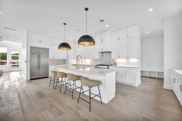 1302 Falcon Cv, Austin, TX 78745 - kitchen with built in fridge, a sink, light wood-style floors, tasteful backsplash, and recessed lighting