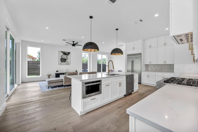 1302 Falcon Cv, Austin, TX 78745 - kitchen featuring a sink, built in refrigerator, ventilation hood, decorative backsplash, and light wood finished floors