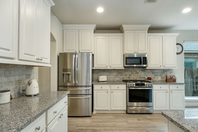 550 Cortona Ln, Georgetown, TX 78628 - kitchen with appliances with stainless steel finishes, recessed lighting, decorative backsplash, and white cabinets