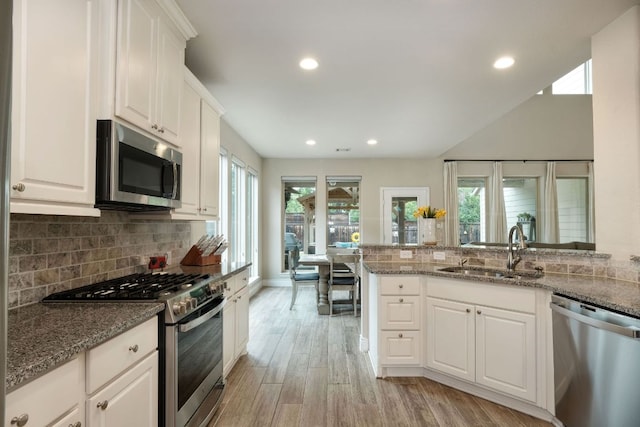 550 Cortona Ln, Georgetown, TX 78628 - kitchen with stainless steel appliances, a sink, recessed lighting, light wood-style flooring, and decorative backsplash