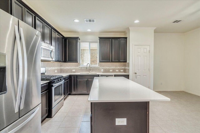 186 Sundown Ave, Buda, TX 78610 - kitchen featuring appliances with stainless steel finishes, a sink, backsplash, a kitchen island, and crown molding
