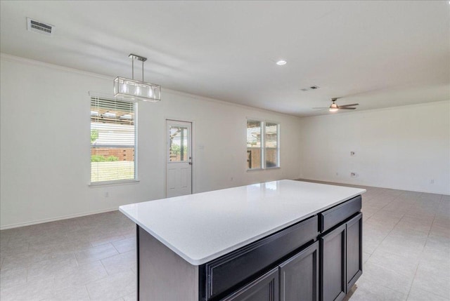 186 Sundown Ave, Buda, TX 78610 - kitchen with open floor plan, ornamental molding, light countertops, ceiling fan, and a kitchen island